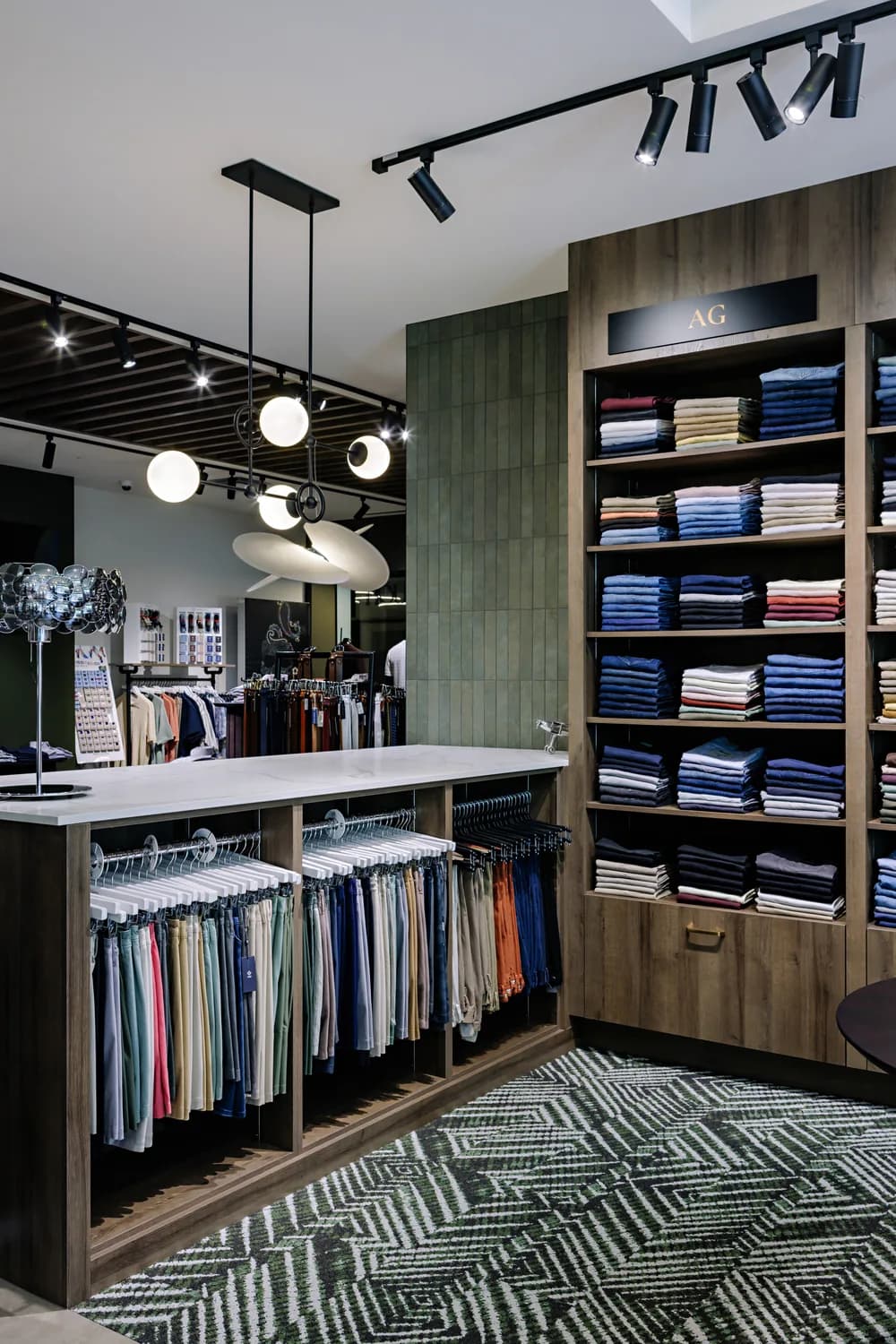 Folded dress shirts on a table beneath brand signage